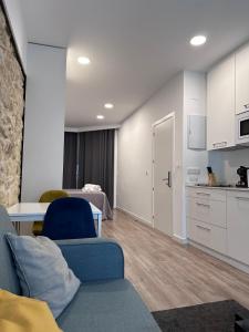 a living room with a blue couch and a kitchen at LOTUS SUITES Alicante in Alicante