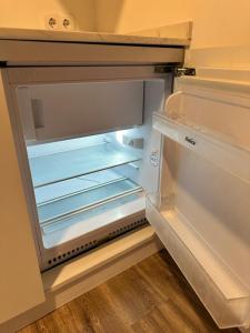 an empty refrigerator with its door open in a room at LOTUS SUITES Alicante in Alicante +18 photos