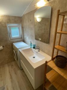 a bathroom with a sink and a washing machine at Apartment Grappa in Vrbnik +5 photos
