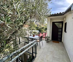 a balcony of a house with a table and chairs at Apartment Grappa in Vrbnik