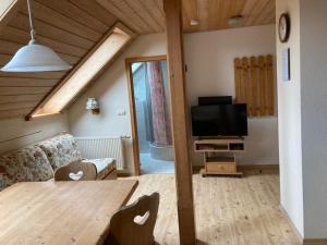 Una sala de estar con una mesa y un televisor. en Barmbichlhof, en Anger