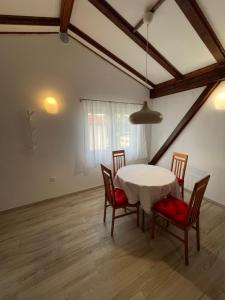 a dining room with a white table and chairs at Apartment Grappa in Vrbnik