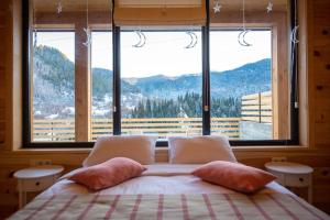 a bedroom with a bed with a large window at Elegant pet-friendly double villa, perfect for couples Svaneti Countryside 4 in Mestia