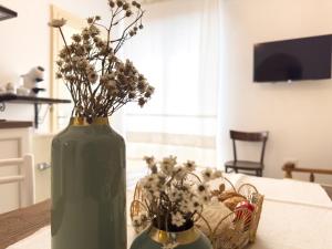 a green vase with flowers in it on a table at La casa di nonna Pietra in Baunei