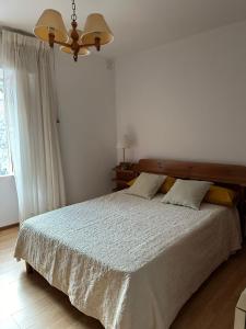 een slaapkamer met een groot bed met een houten hoofdeinde bij casa gerente in Muros