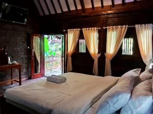a large bed in a room with a window at Tahlia's Villa in Sorongjukung