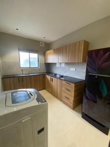 a kitchen with a washing machine and a washer at Muziris Manor Residency in Cochin