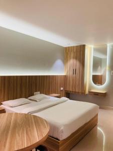 a bedroom with a large bed and a table at Muziris Manor Residency in Cochin