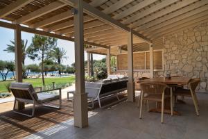 a patio with a table and chairs and a piano at Elya Beach Luxury Suites in Ayios Theodhoros