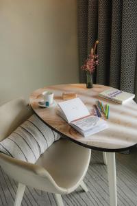 a wooden table with a book and a cup of coffee at Thalazur Arcachon in Arcachon