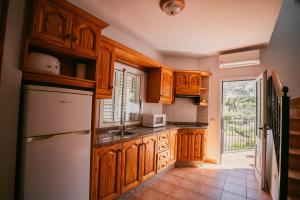 a kitchen with wooden cabinets and a white refrigerator at Casa Rural Guadá in Valle Gran Rey