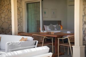 a room with a bed and a table and chairs at Elya Beach Luxury Suites in Ayios Theodhoros