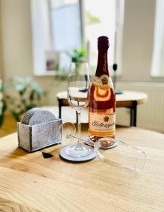 une bouteille de champagne et un verre sur une table dans l'établissement Appartement "STADTGEFLÜSTER" im Zentrum, inkl Stellplatz, 2 Betten, Babybett, Balkon, gratis Kaffee und Tee, WLAN, à Bautzen