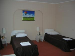 ズラトウーストにあるGuest House Puteshestvennikのベッド2台が備わる部屋、壁に絵が飾られた部屋