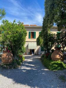 ein Gebäude mit zwei großen Bäumen davor in der Unterkunft Albergo Pensione Bartoli in Castiglioncello