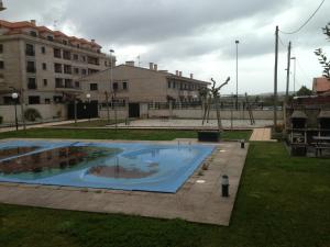 a large swimming pool in a park with a building at Apartamento en A revolta in Sanxenxo