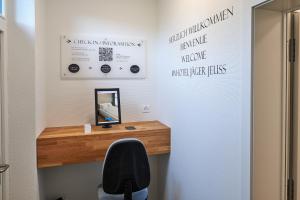 JeussHotel Jäger Jeuss - Murten - Self-Check-in的一间带书桌、椅子和镜子的房间