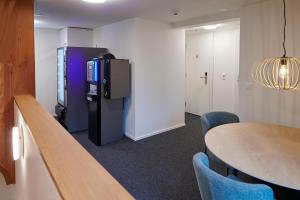 JeussHotel Jäger Jeuss - Murten - Self-Check-in的配有电视和桌椅的房间