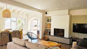 sala de estar con sofá y TV de pantalla plana en Villa las palmeras, en Benissa