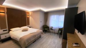 a hotel room with a bed and a television at Green Nazar Hotel in Trabzon