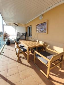 comedor con mesa de madera y bancos en Atico Fonoll, en Salou
