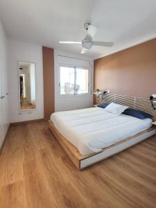 Un dormitorio con una gran cama blanca con ventana. en Atico Fonoll, en Salou