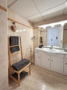 y baño con lavabo, silla y espejo. en Atico Fonoll, en Salou