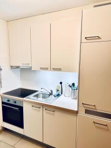 a kitchen with white cabinets and a sink at Mon Bijoux in Ascona +9 photos