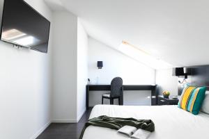 TV a/nebo společenská místnost v ubytování Logis Hôtel & Restaurant La Villa Bleue