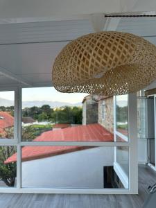 a wicker chandelier hanging from the ceiling of a house at casa gerente in Muros