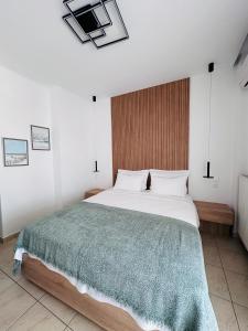 a bedroom with a large bed with a green blanket at Hotel Filoxenia in Ouranoupoli