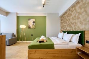 a bedroom with a bed with a green wall at Soleil Anne std - Infinity Pool & Spa Resort in Mamaia +56 photos