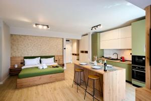 a bedroom with a green bed and a kitchen at Soleil Anne std - Infinity Pool & Spa Resort in Mamaia
