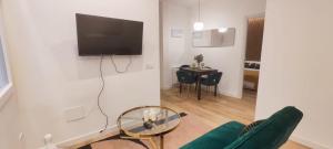ein Wohnzimmer mit einem Sofa und einem TV an der Wand in der Unterkunft La Casita del Retiro in Madrid