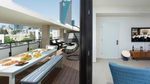a balcony with a table and chairs on a building at Renovated 3BR Penthouse by HolyGuest in Tel Aviv