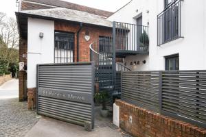 a building with a gate with a sign in front of it at Central Two Bedroom Apartments with Free Parking in St. Albans