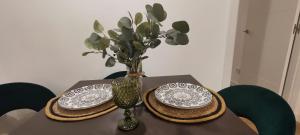 einen Tisch mit zwei Platten und eine Vase mit Blumen in der Unterkunft La Casita del Retiro in Madrid