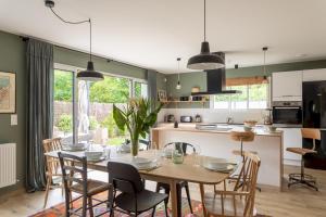 a kitchen and dining room with a table and chairs at La Cabane des Ebihens - A moins d'1km de la plage in Lancieux