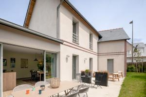 an extension of a house with a patio with a table and chairs at La Cabane des Ebihens - A moins d'1km de la plage in Lancieux
