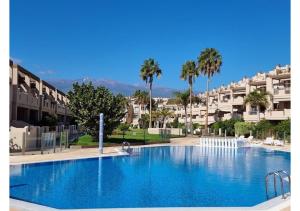 a large swimming pool in front of some buildings at 100 Steps to the Sand. in La Tejita