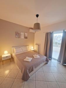 a bedroom with a bed with two towels on it at Comfortable Apartment close to Rafina port in Rafina