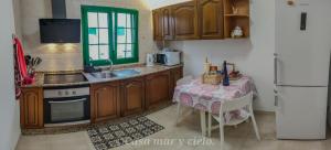 uma cozinha com uma mesa, um lavatório e um frigorífico em Casa mar y cielo em Playa Blanca