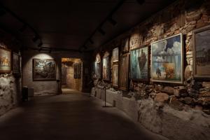 un corridoio in un museo con dipinti alle pareti di Art Hotel Roma a Liepāja
