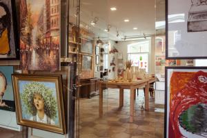 a room with a table and paintings on the wall at Art Hotel Roma in Liepāja