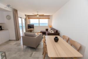 un soggiorno con tavolo e divano di Deluxe apartment sea views La Herradura a La Herradura