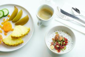 a table with a bowl of oatmeal and a plate of fruit at Thalazur Arcachon in Arcachon