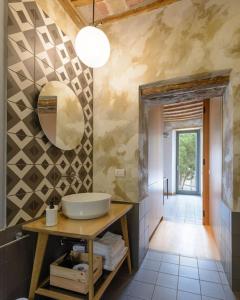 baño con lavabo y espejo en la pared en The View - Sunset & Relax - Suite - Appartamenti Vista Lago en Passignano sul Trasimeno