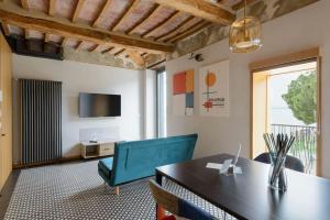 comedor con mesa, sillas y TV en The View - Sunset & Relax - Suite - Appartamenti Vista Lago en Passignano sul Trasimeno