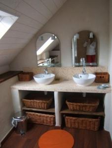 un bagno con due lavandini e uno specchio di Gites de la Haie a Plouégat-Moysan Altre 46 foto