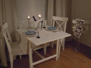 een witte tafel met twee stoelen en een witte tafel met glazen bij Appartement Seabird in Zandvoort